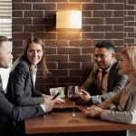 A group of business professionals having a lively discussion in a modern café setting.